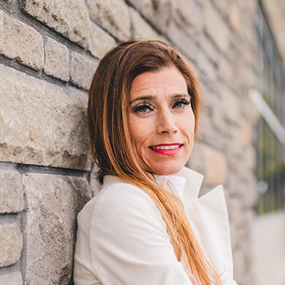 Chiropractor Angela DiMartino smiling in a white jacket.