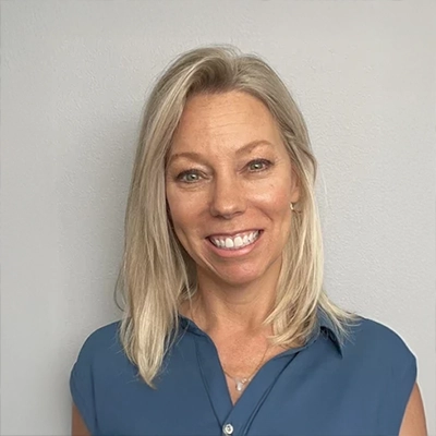 Chiropractor Janet Bednarz smiling in a blue shirt.