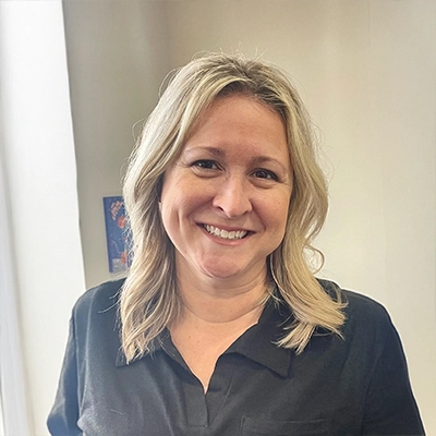 Chiropractic Chesterfield MI Michelle Meet The Team Smiling Staff Member Standing Inside The Clinic